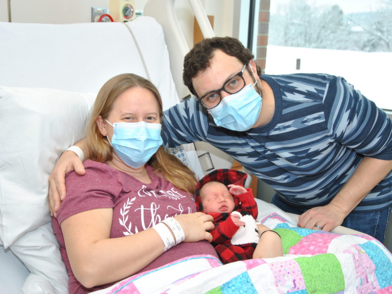 Parents posing with their newborn baby