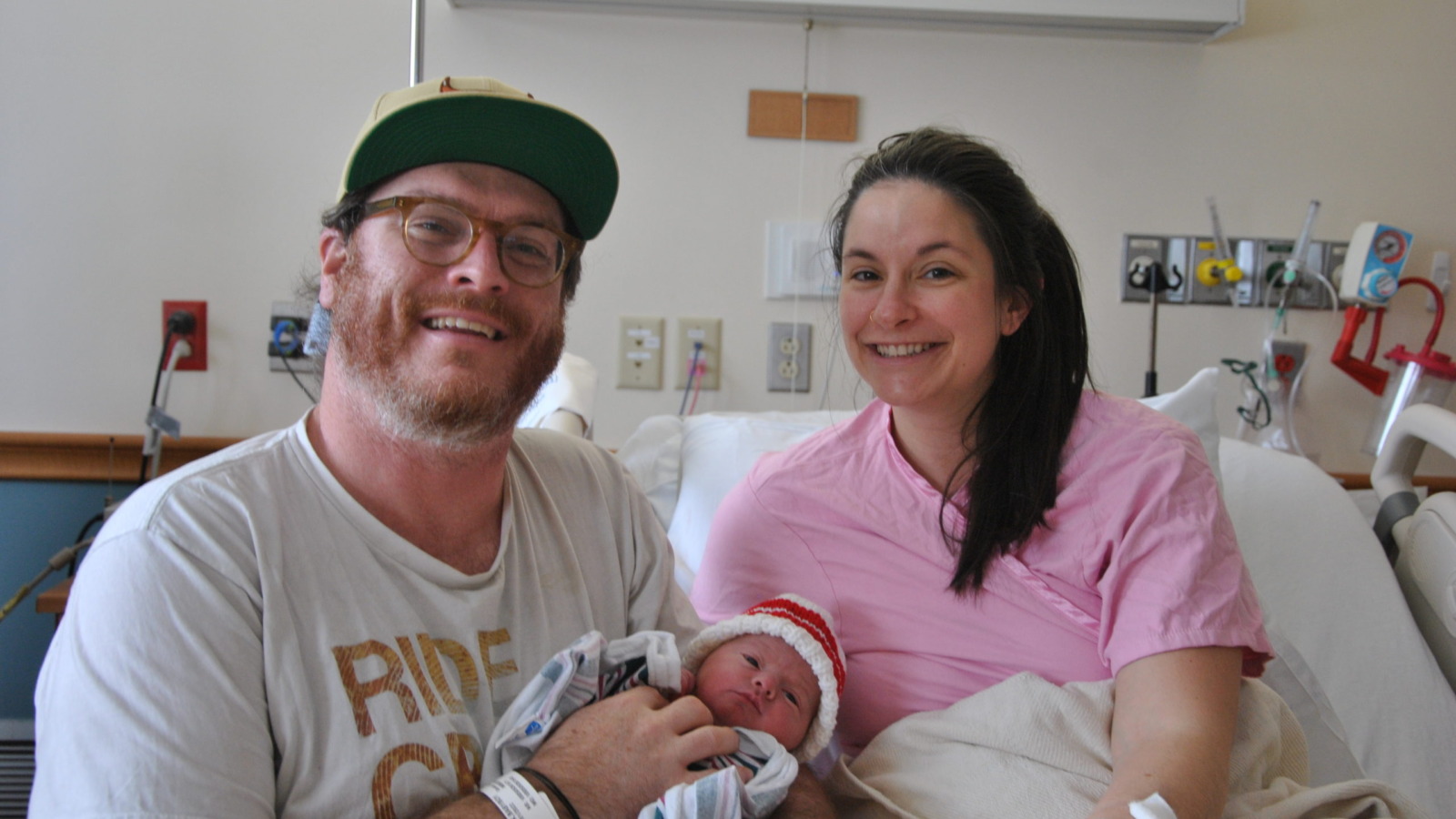 Parents holding newborn in an NMC birthing center recovery room