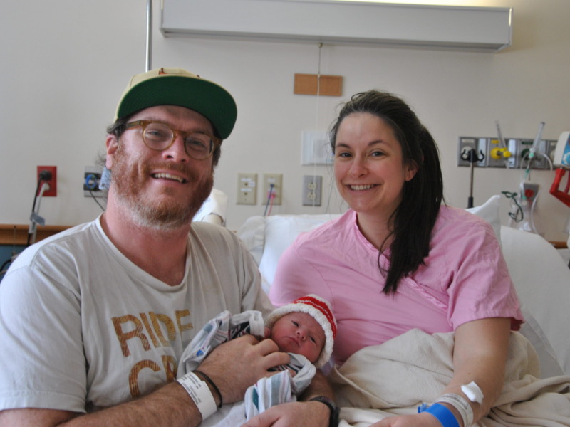 Parents holding newborn in an NMC birthing center recovery room