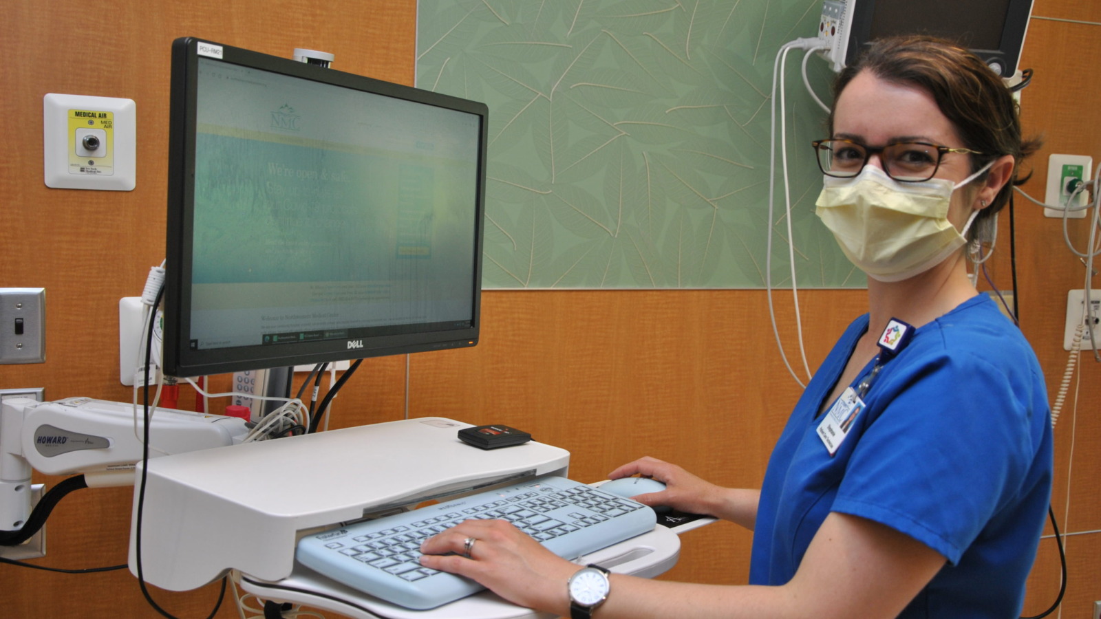 Nurse documenting on an in-room computer