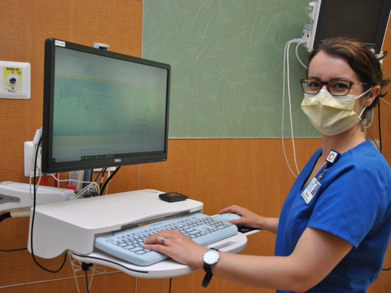 Nurse documenting on an in-room computer