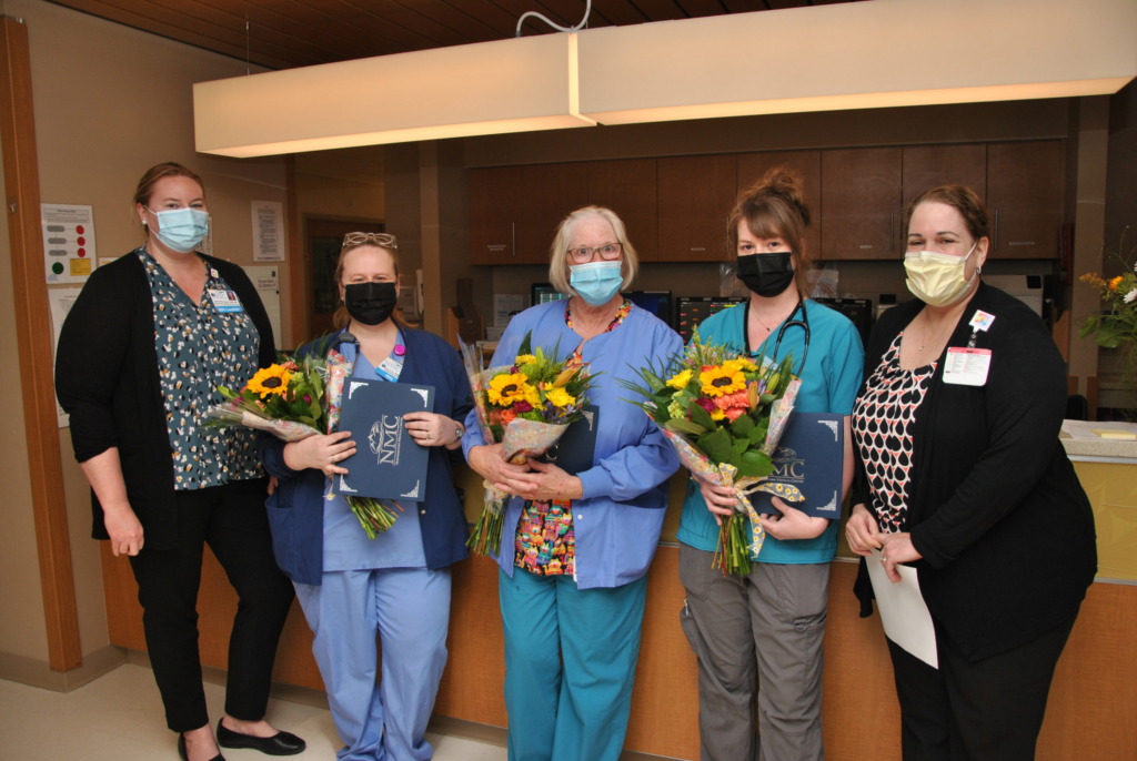 Group of NMC nurses being presented with flowers during nurses' week