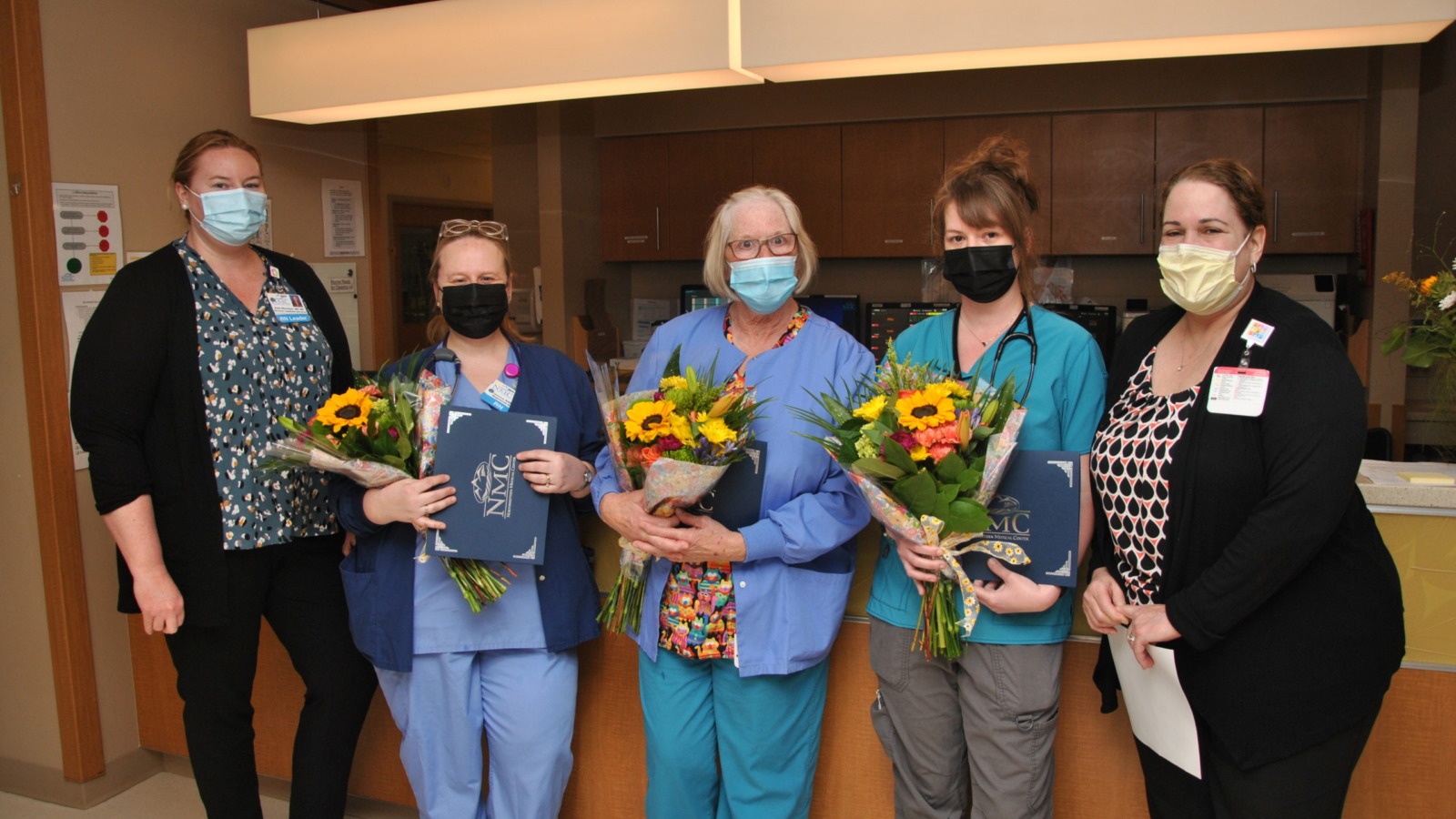 Group of NMC nurses being presented with flowers during nurses' week