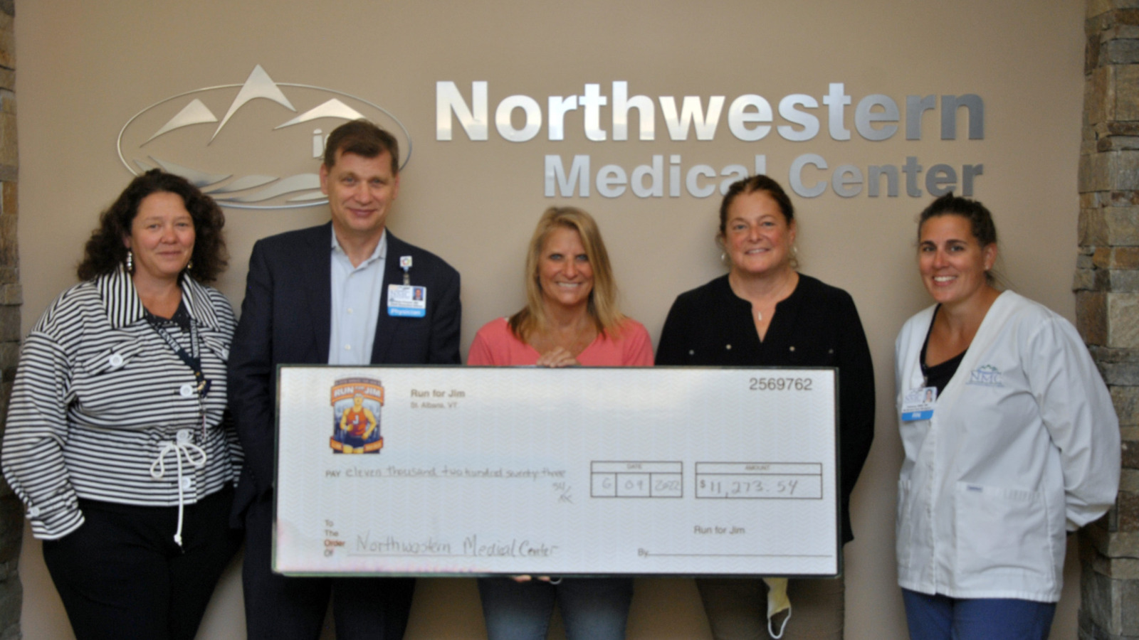 Northwestern Medical Center staff presenting a ceremonial check to representatives of the Jim Bashaw Fund