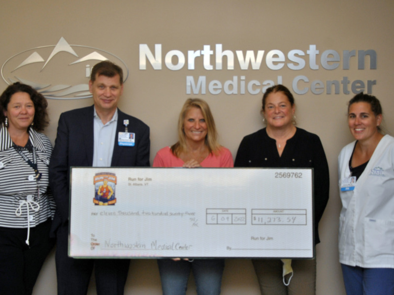 Northwestern Medical Center staff presenting a ceremonial check to representatives of the Jim Bashaw Fund