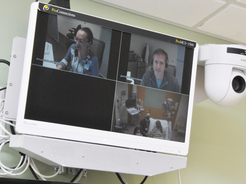 computer monitor with image of providers caring for patients remotely