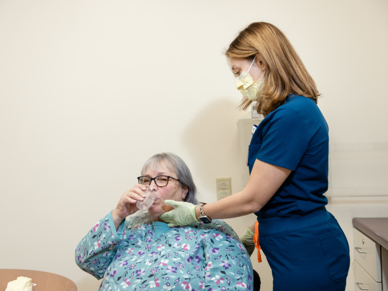 Speech therapist assists a patient during a swallow testing procedure