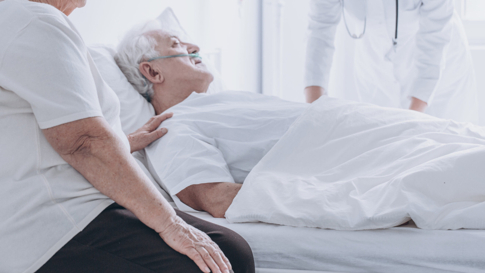 close up image of a patient in a hospital bed, accompanied by a doctor and family member
