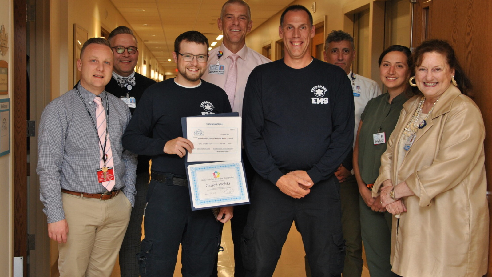 Group of Northwestern Medical Center leaders presenting EMS employees with the "caring award"