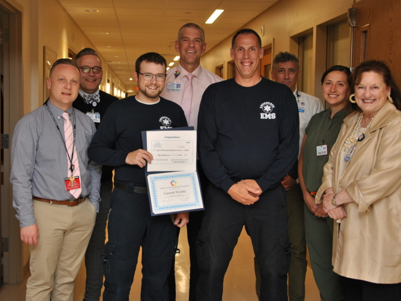 Group of Northwestern Medical Center leaders presenting EMS employees with the "caring award"