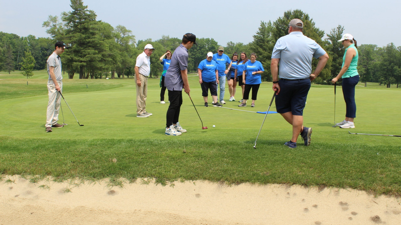 group of golfers watching a putting competition