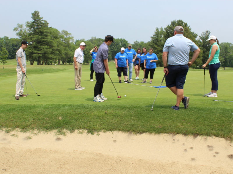 group of golfers watching a putting competition
