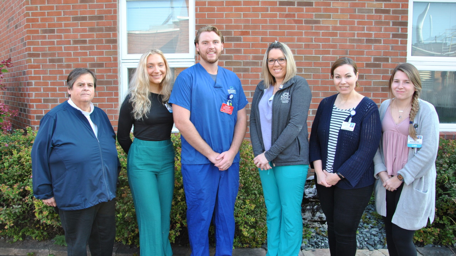 Group picture of nurses in front of an exterior wall