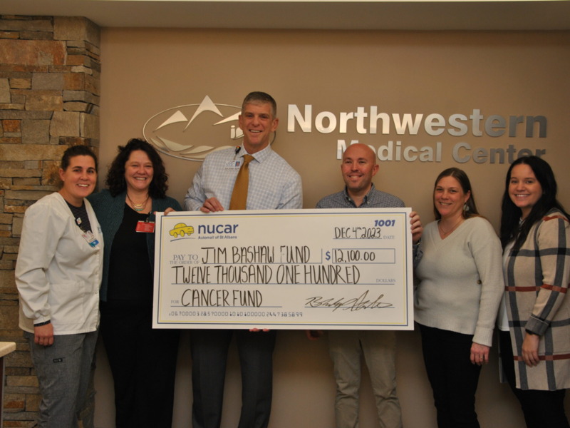 Northwestern Medical Center CEO, Peter Wright and staff present a ceremonial check to representatives of the Jim Bashaw fund