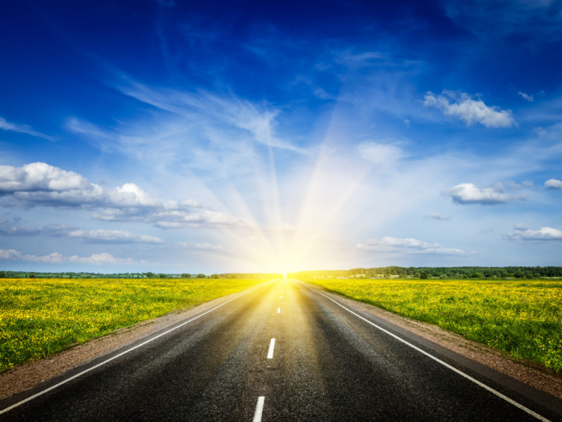 straight highway heading into bright sun
