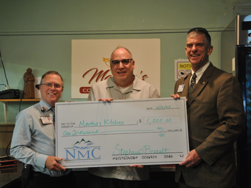 Peter Wright, CEO Northwestern Medical Center and Jonathan Billings, COO present a ceremonial check to a representative of Martha's Kitchen