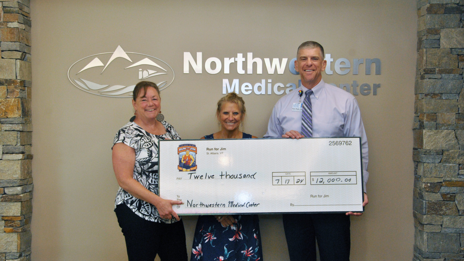 Peter Wright, CEO Northwestern Medical Center and Kate Laddison, Director of Community Relations present a ceremonial check to a representative of the Jim Bashaw Fund