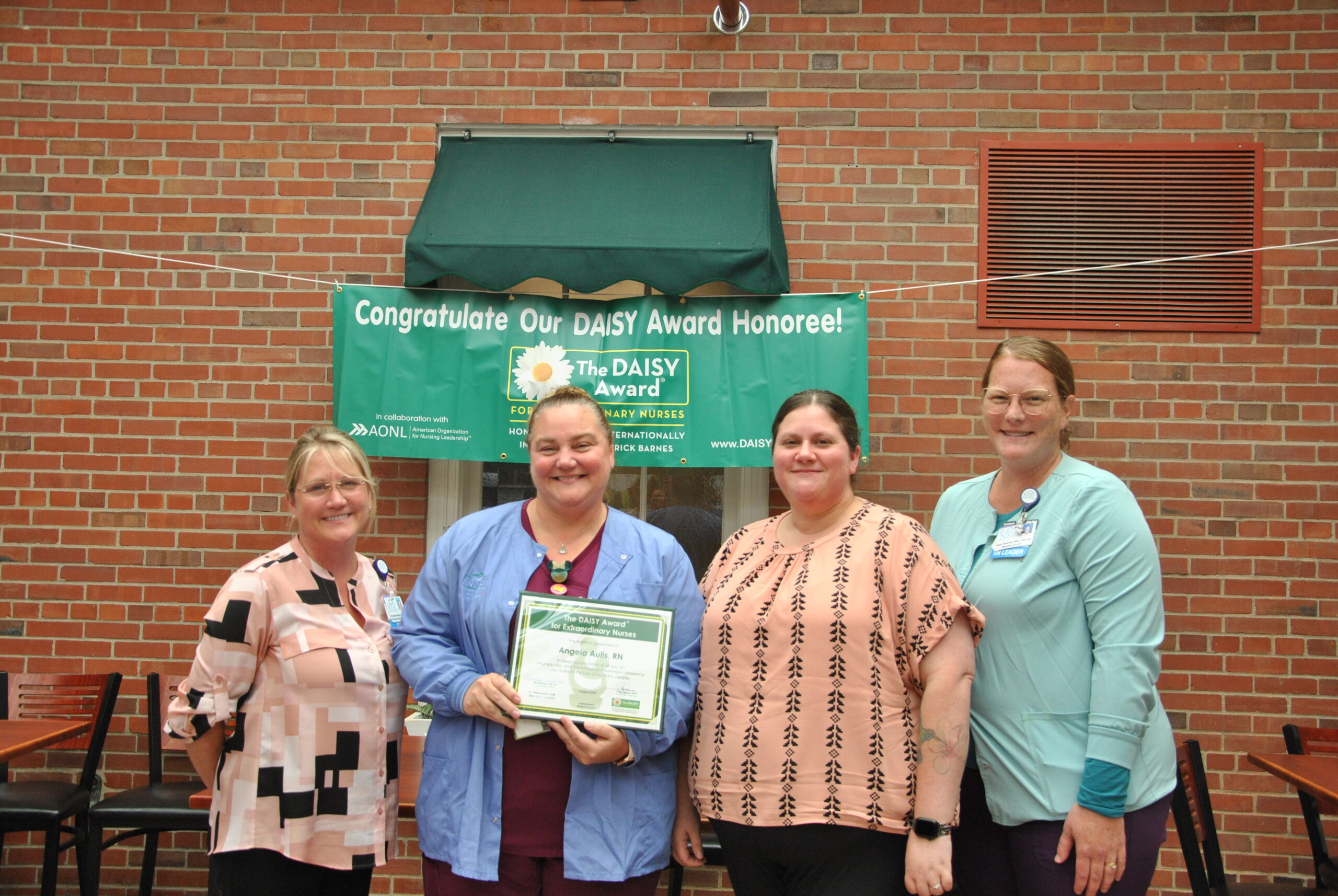 Daisy Award winner Angie Aulis posing with colleagues