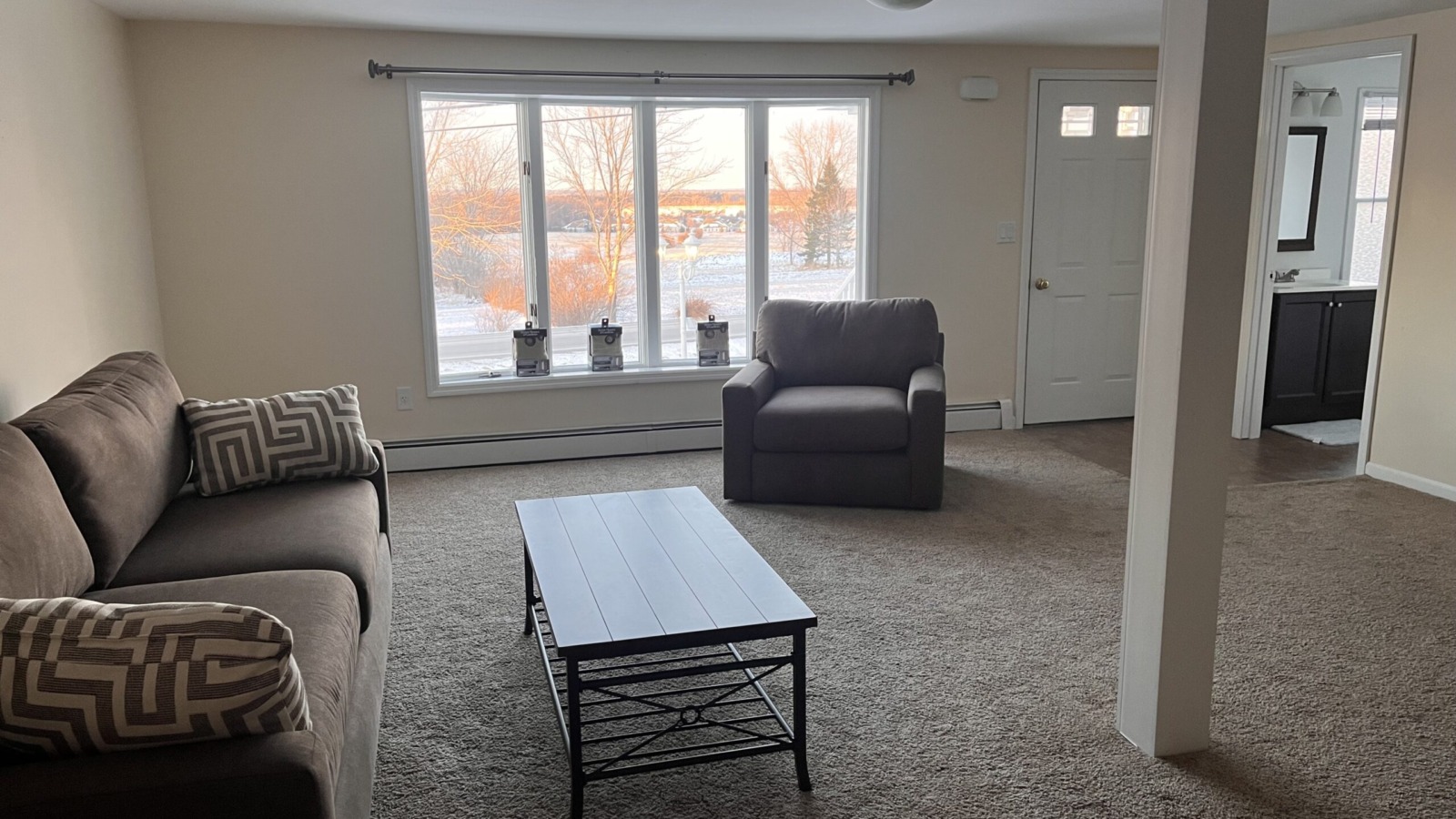 Sofa and Chair in a carpeted apartment living room