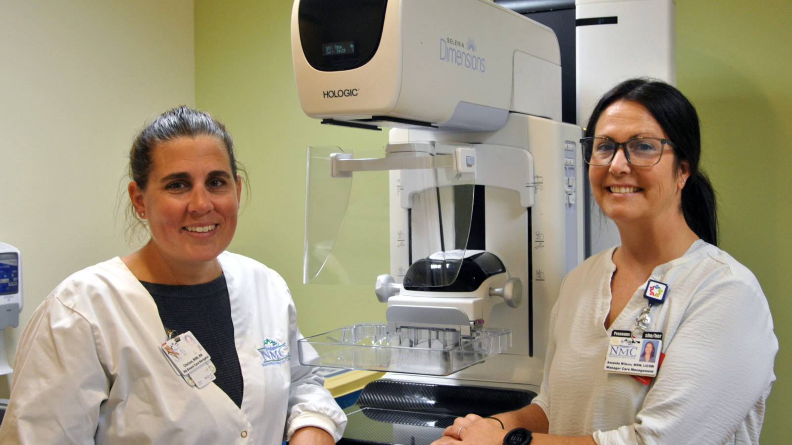 Hospital staff posing with a mammography imaging device