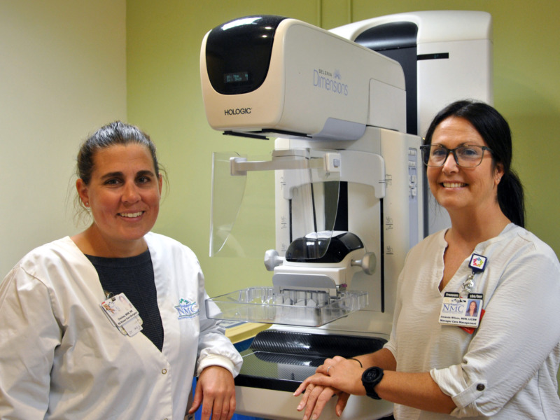 Hospital staff posing with a mammography imaging device