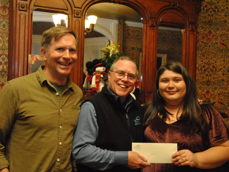Jonathan Billings COO at Northwestern Medical Center presents a donation check to a representative of Voices Against violence