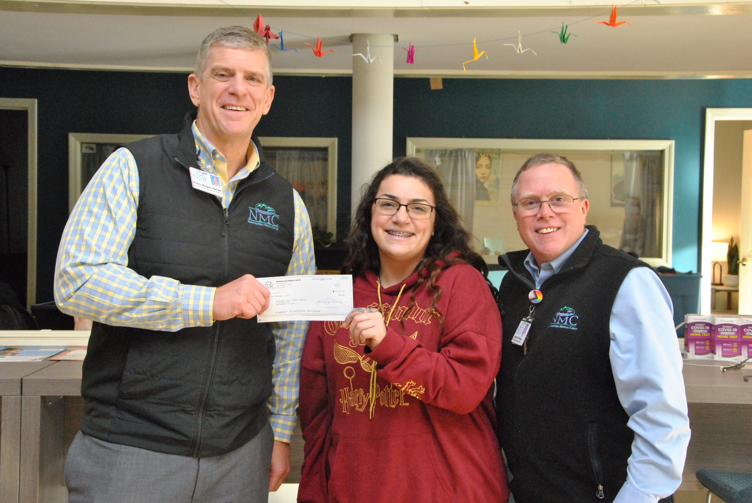 Peter Wright, CEO and Jonathan Billings COO at Northwestern Medical Center present a donation check to a representative of Spectrum Youth and Family Services.