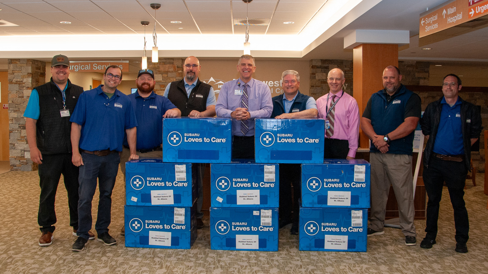 Peter Wright, CEO of Northwestern Medical stands with representatives of Haddad Subaru in the hospital main lobby with a donation of eight boxes of blankets