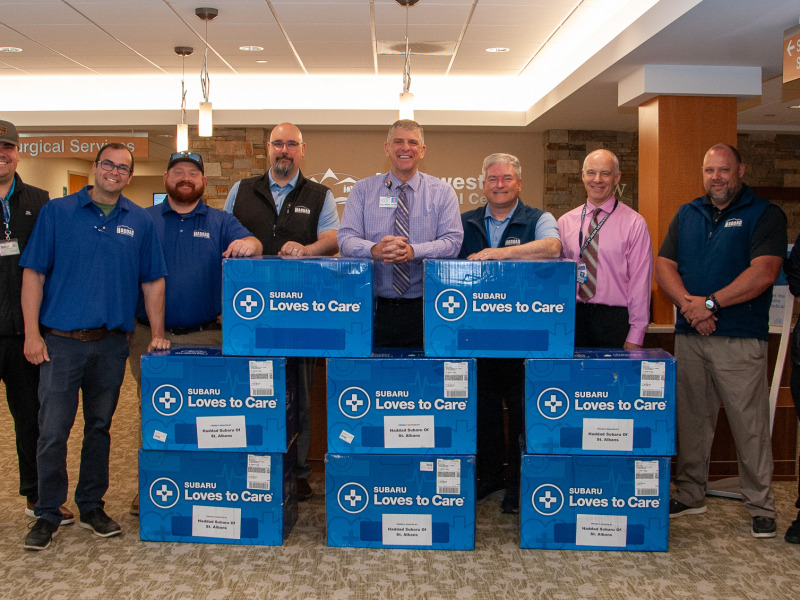 Peter Wright, CEO of Northwestern Medical stands with representatives of Haddad Subaru in the hospital main lobby with a donation of eight boxes of blankets