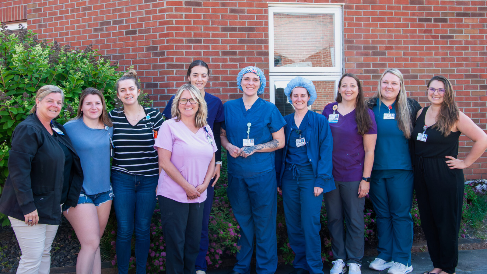 Michelle Buck, Chief Nursing Officer and Kelly Campbell, Director of Organizational Development pose with a group of nurses graduating from Northwestern Medical Centers Pathways program.