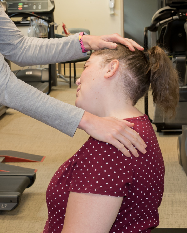 Physical Therapist helping patient through neck stretch