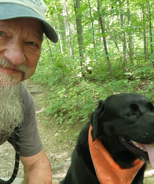Pet Therapy volunteer Michael and his dog Lemmy in woods