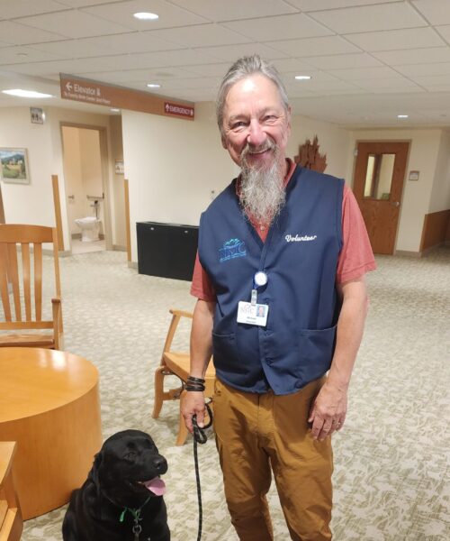 Pet Therapy volunteer Michael and his dog Lemmy standing in hospital lobby