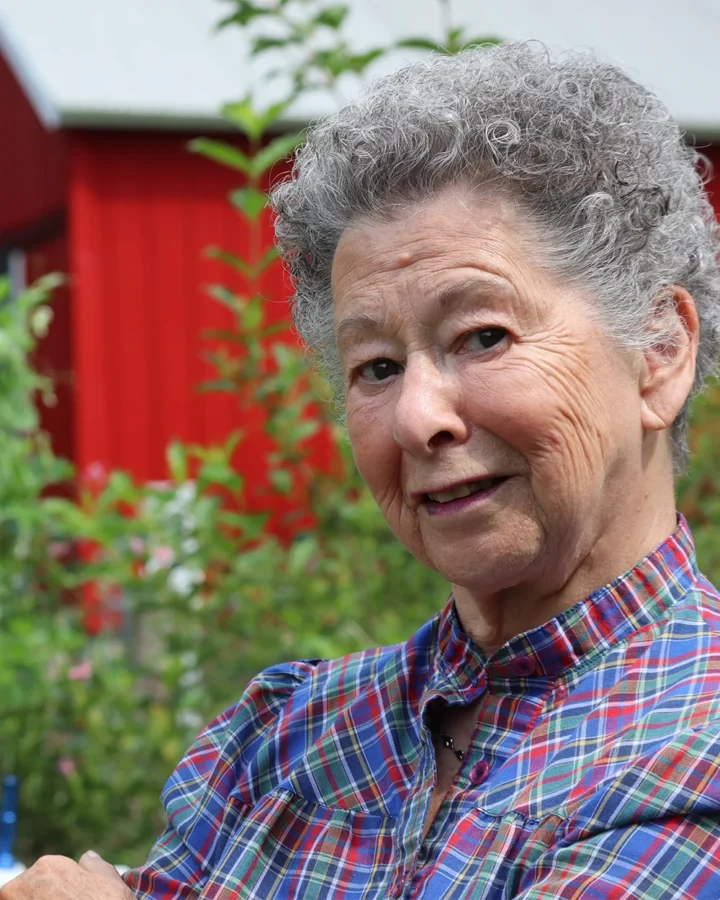 Joyce Berger standing in her garden looking at the camera