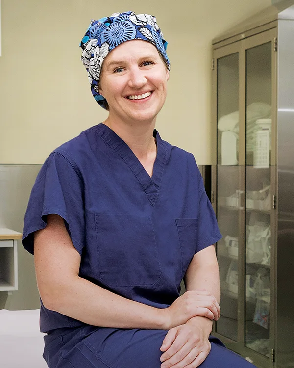 Surgeon sitting on table smiling at camera