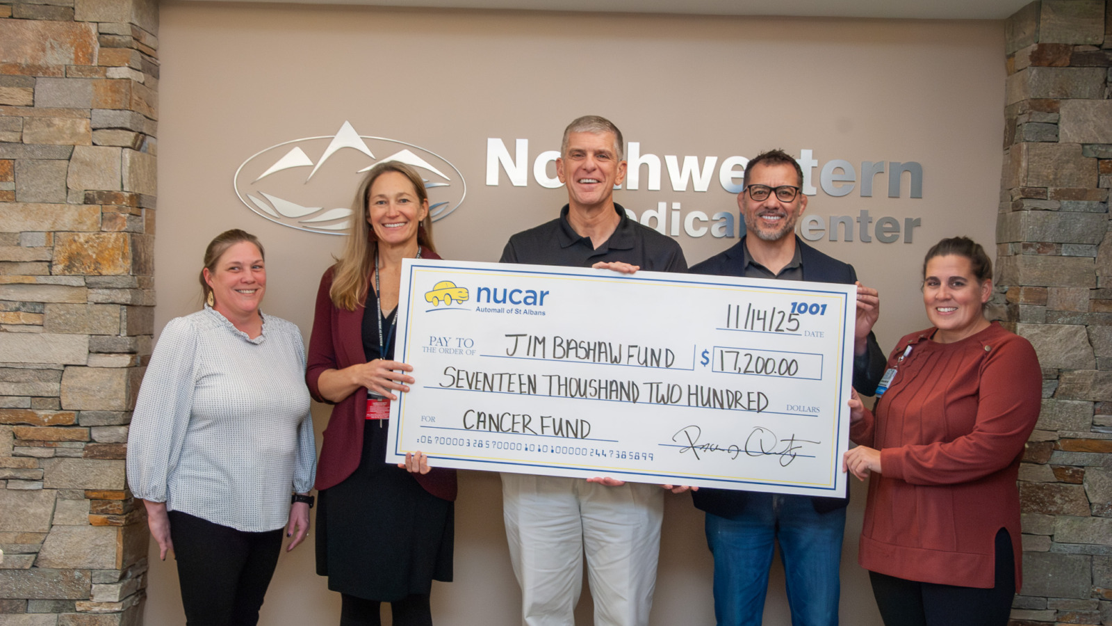 Check being presented to NMC by Nucar Automall of St. Albans for Jim Bashaw Fund