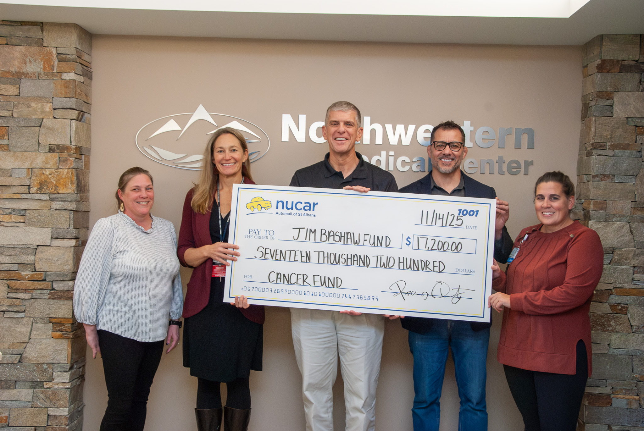 Check being presented to NMC by Nucar Automall of St. Albans for Jim Bashaw Fund