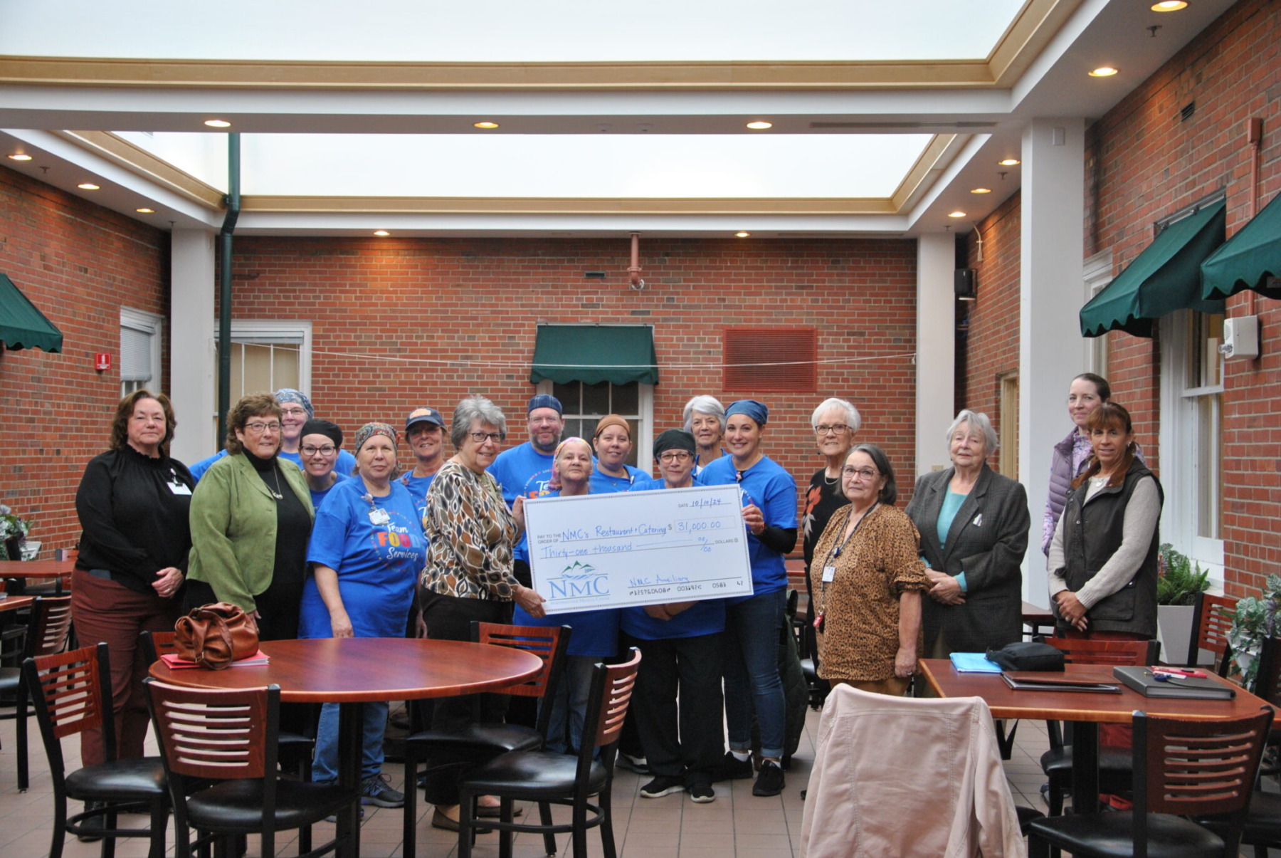Auxiliary Board Members present a check to NMC’s Restaurant and Catering team.