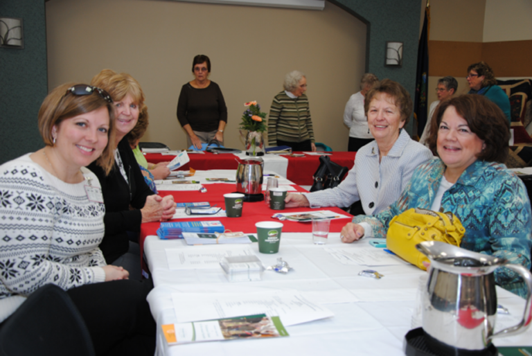 Auxiliary members chat with a guest speaker before a meeting in NMC’s Conference Center.