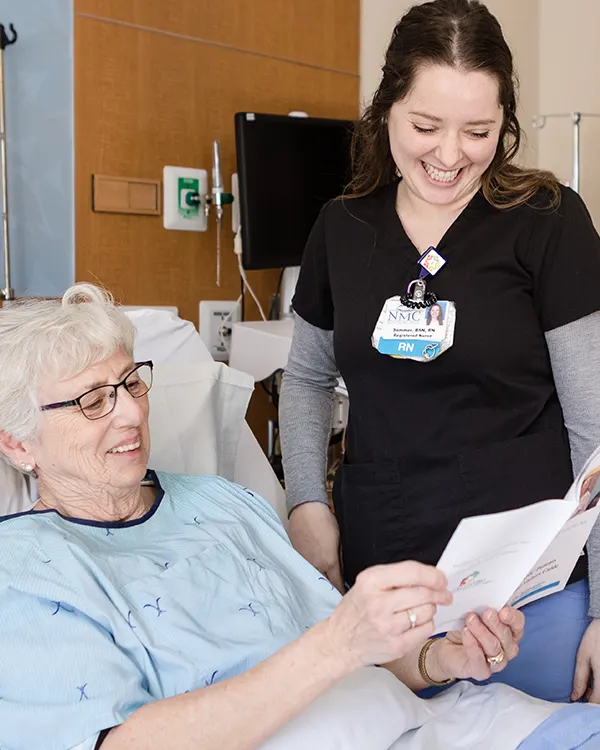 Nurse helping patient, looking at medical information