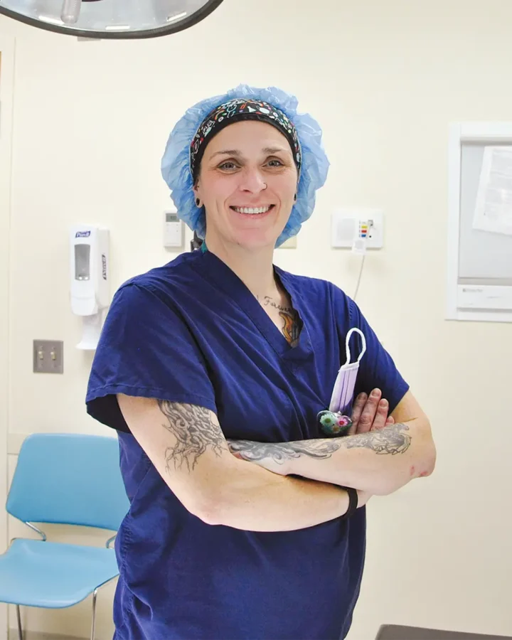 Nursing with surgical garb on looking at camera and smiling
