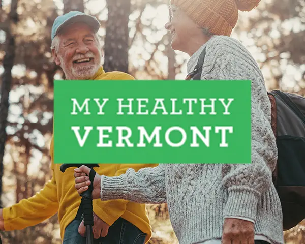 My Healthy Vermont logo laid over an elderly couple hiking