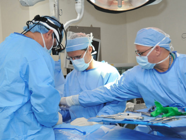 three surgeons during surgery