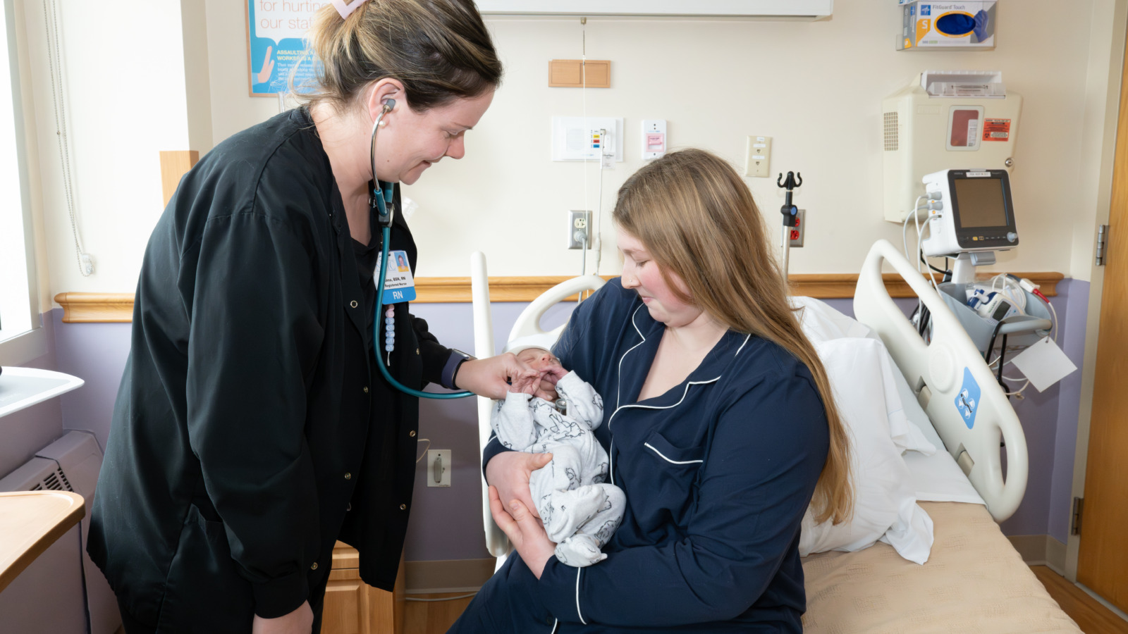 A nurse using a stethoscope to examine a newborn.