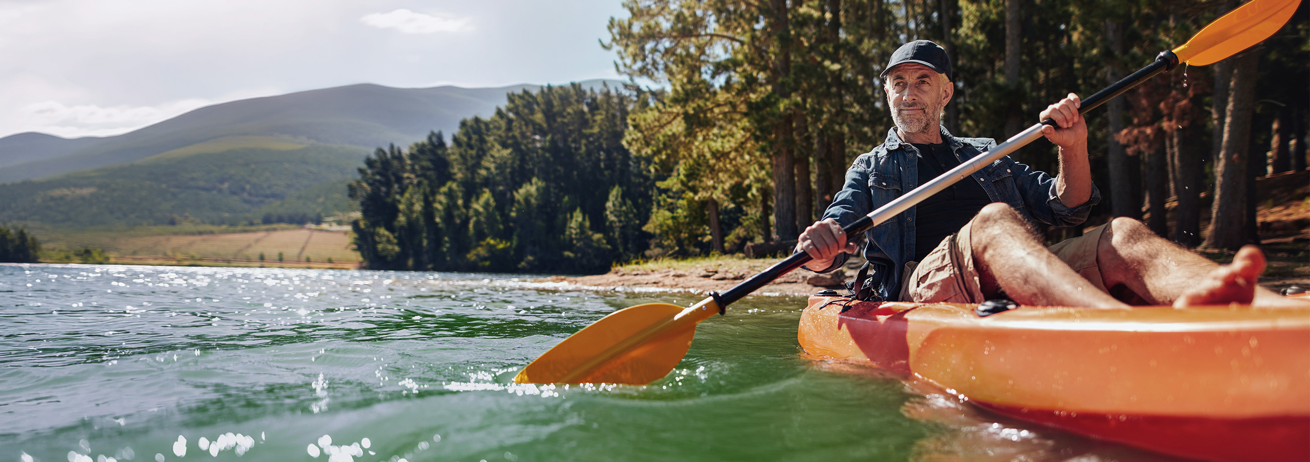 Photo of an older man kayaking.