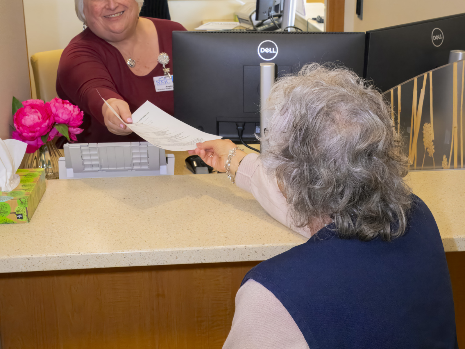 patient registration interacting with patient to help fill out paperwork