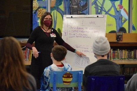Woman speaking to children in a classroom