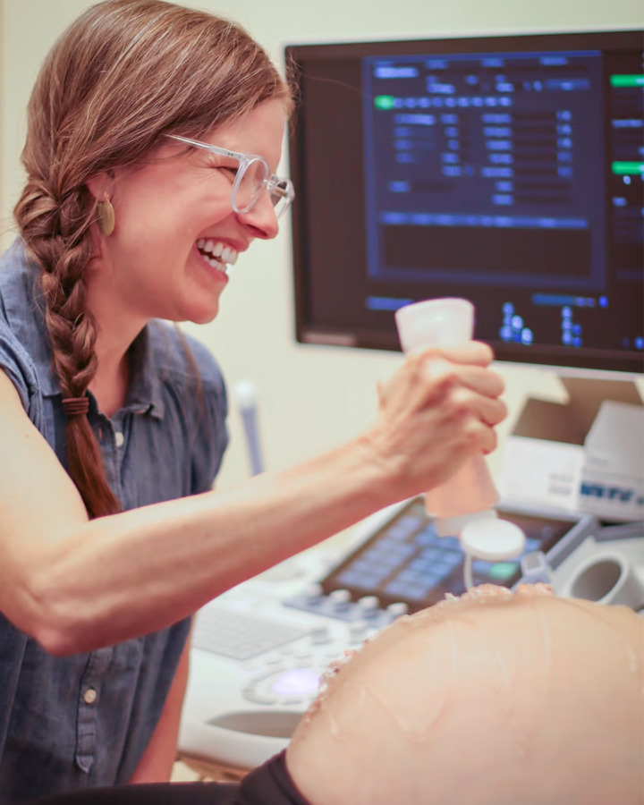 Provider putting gel on a pregnant woman's stomach for ultrasound